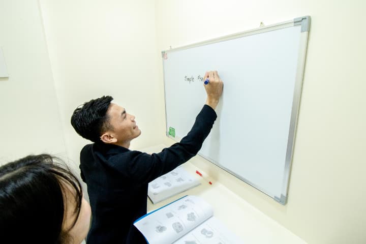 マンツーマン教室で指導する男性講師と日本人の女性生徒