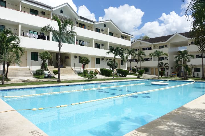 English Fella 2の屋外プールと学生寮の外観。広々としたプールエリアがキャンパス中央に配置され、リゾートのような環境で留学生活を楽しめる。