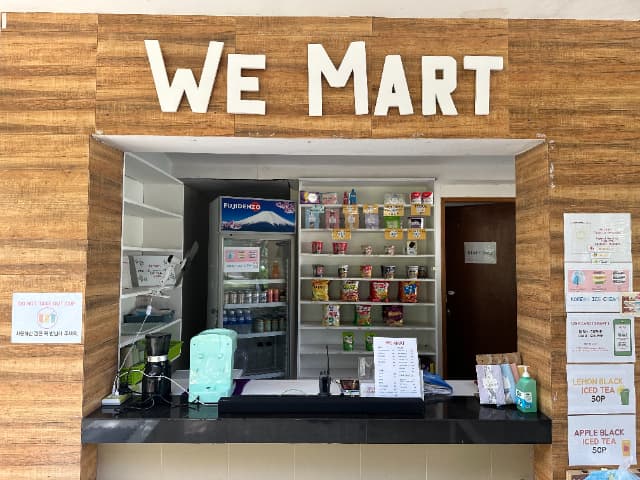 CLARK WE ACADEMYの売店WE MART。カップラーメンやスナック、ドリンクが並ぶカウンターの様子