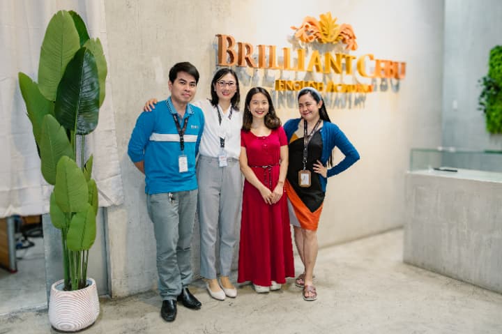 Brilliant Cebu のエントランス付近で撮影された、親切な講師/スタッフの集合写真。