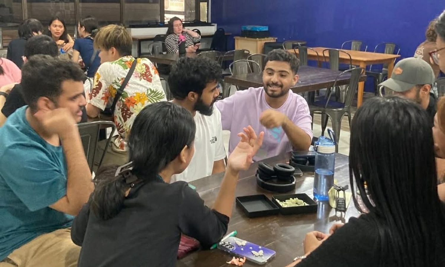 3D Academyの現地大学生との交流会。多国籍の留学生がテーブルを囲んで英語で話している