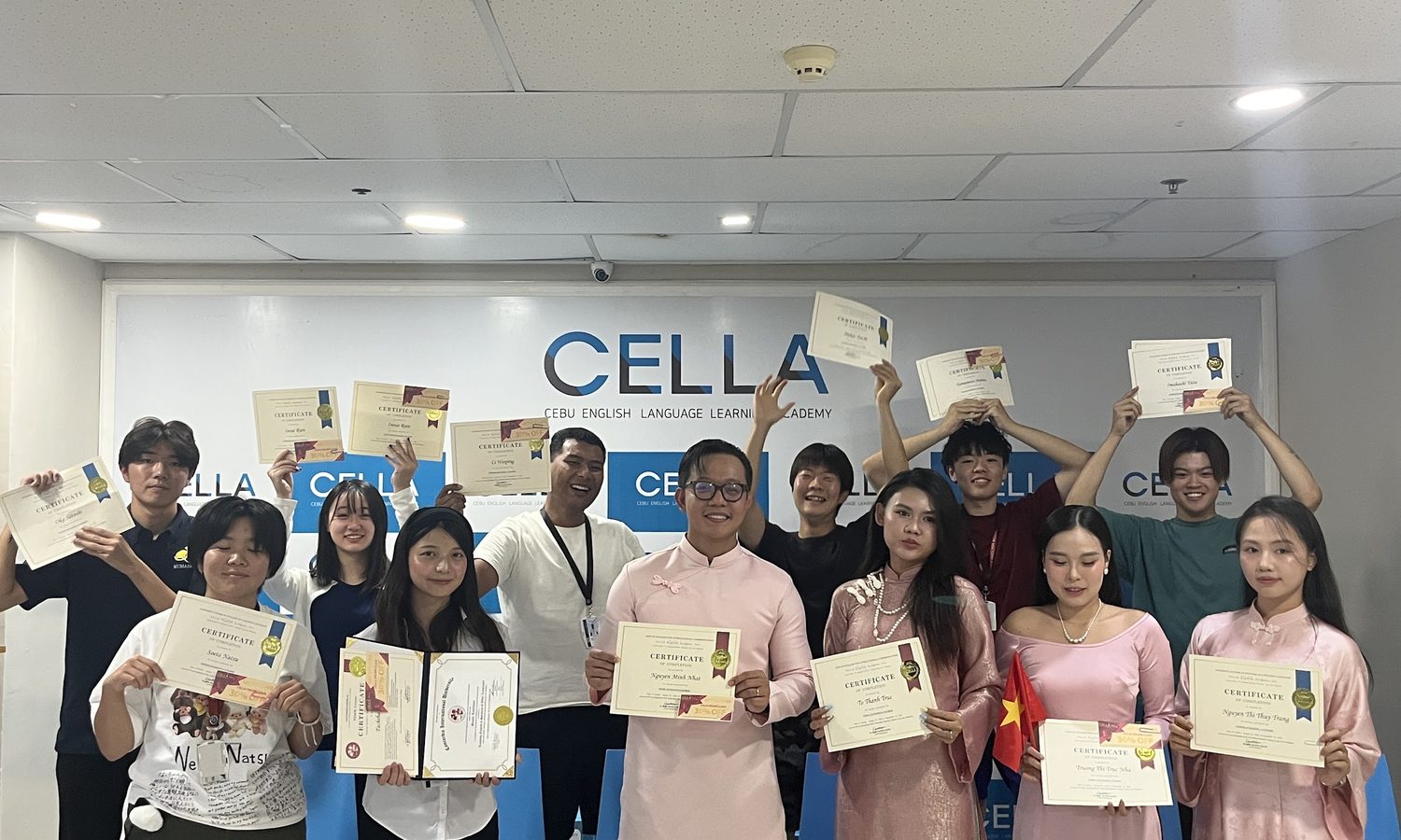 CELLA Uni スパルタ校の卒業式で修了証を掲げる学生たち