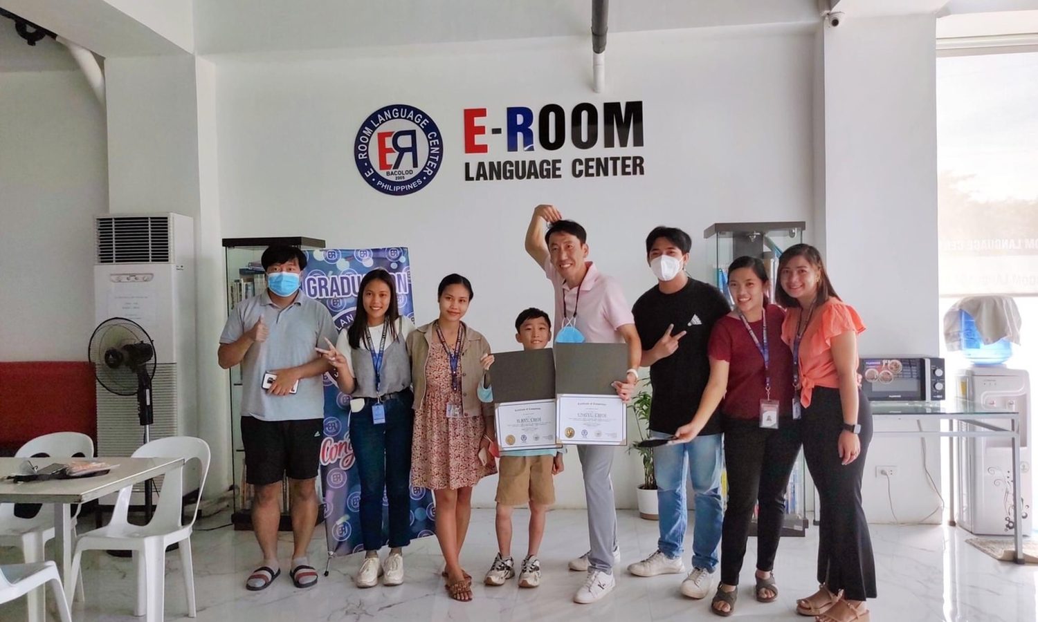 E-roomの卒業式で学生と並ぶスタッフ