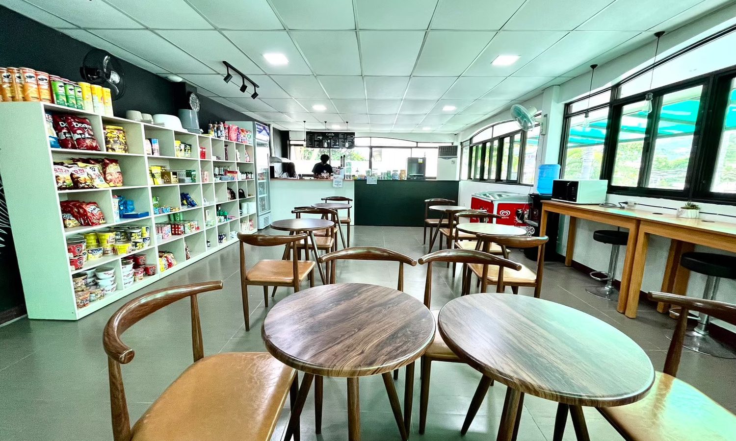 English Fella 1のカフェ「Cafella」。売店の棚とテーブル席がある