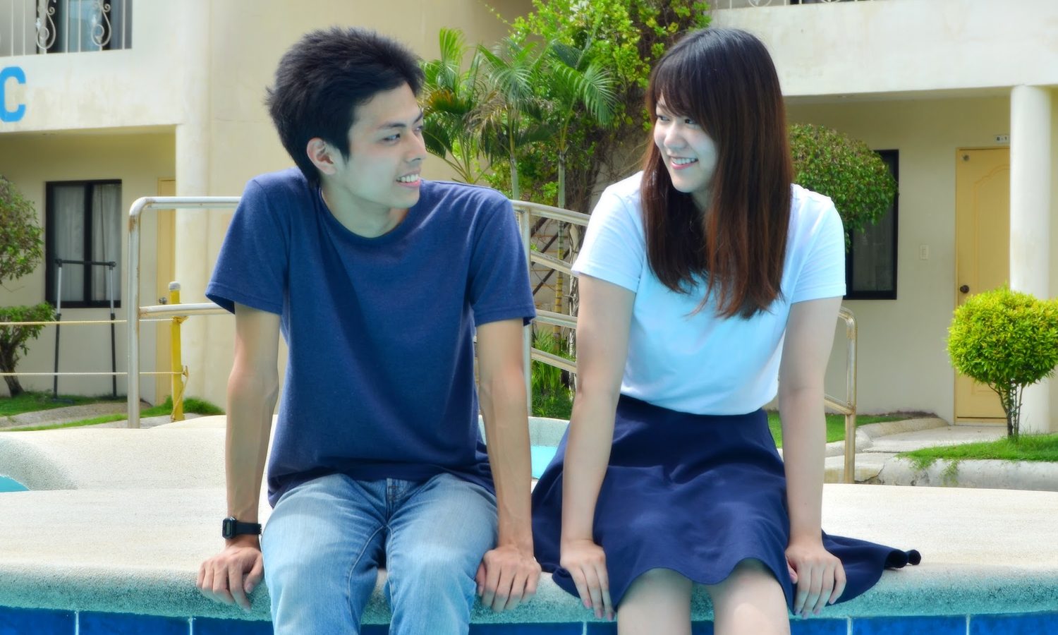 English Fella 1のプールサイドに座って話す留学生2人