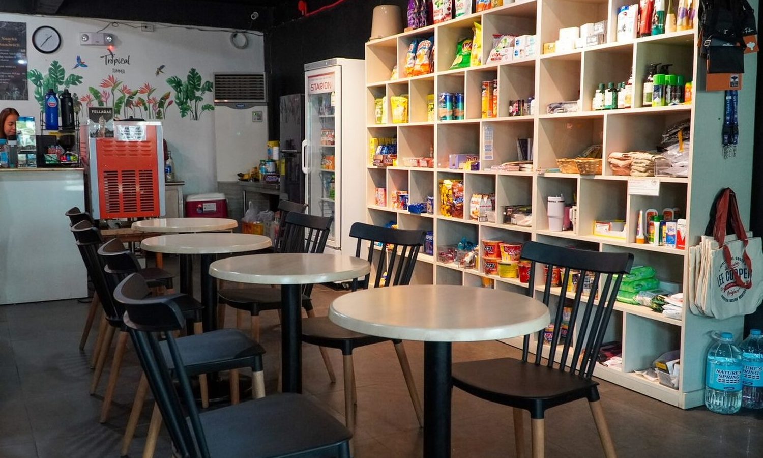 English Fella 2のカフェ「Cafella」。売店の棚とテーブル席がある