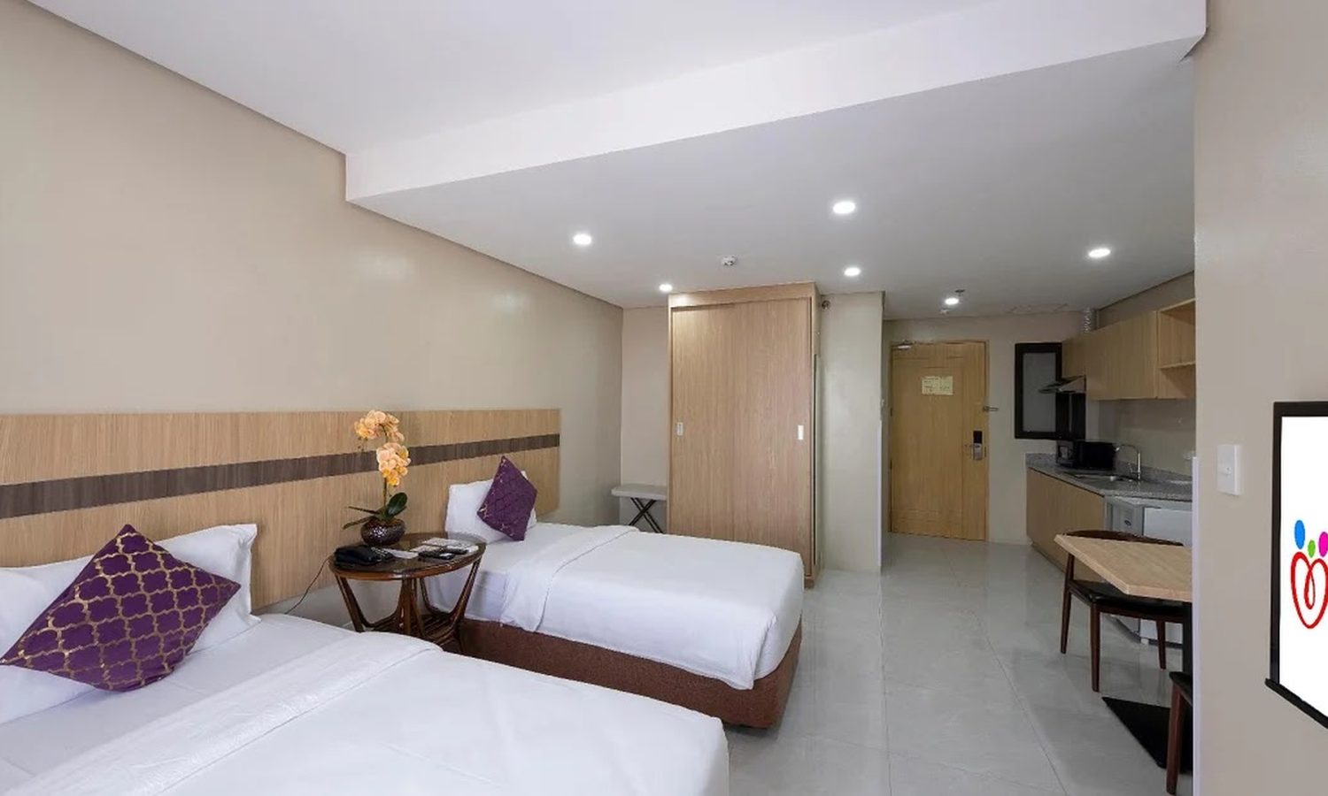 I.BREEZE の外部寮コンドミニアム（Cebu Family Suites）の寝室。ホテルのようなベッドとテレビがある