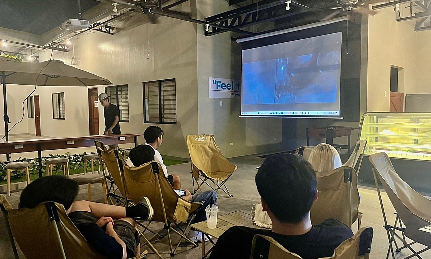 I.BREEZE のムービーナイト。スクリーンの前にキャンプチェアを並べて映画を見る留学生