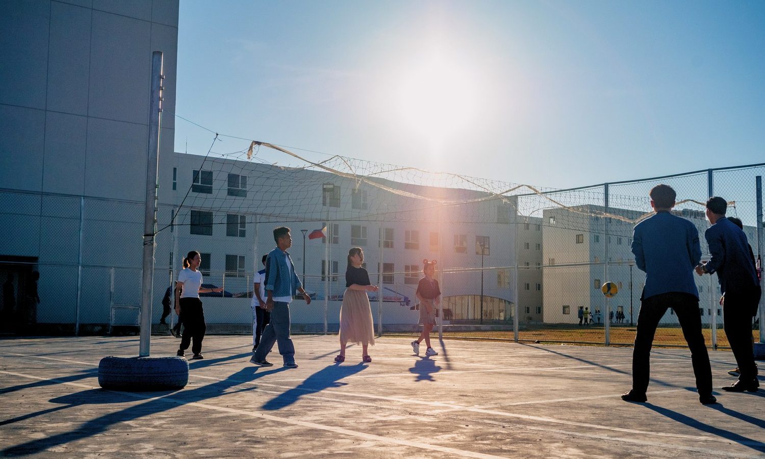 夕方の屋外コートで遊ぶ学生