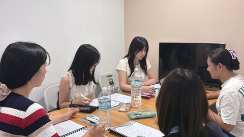 PIAのESLコースのグループ授業。留学生4人がノートを広げて話している