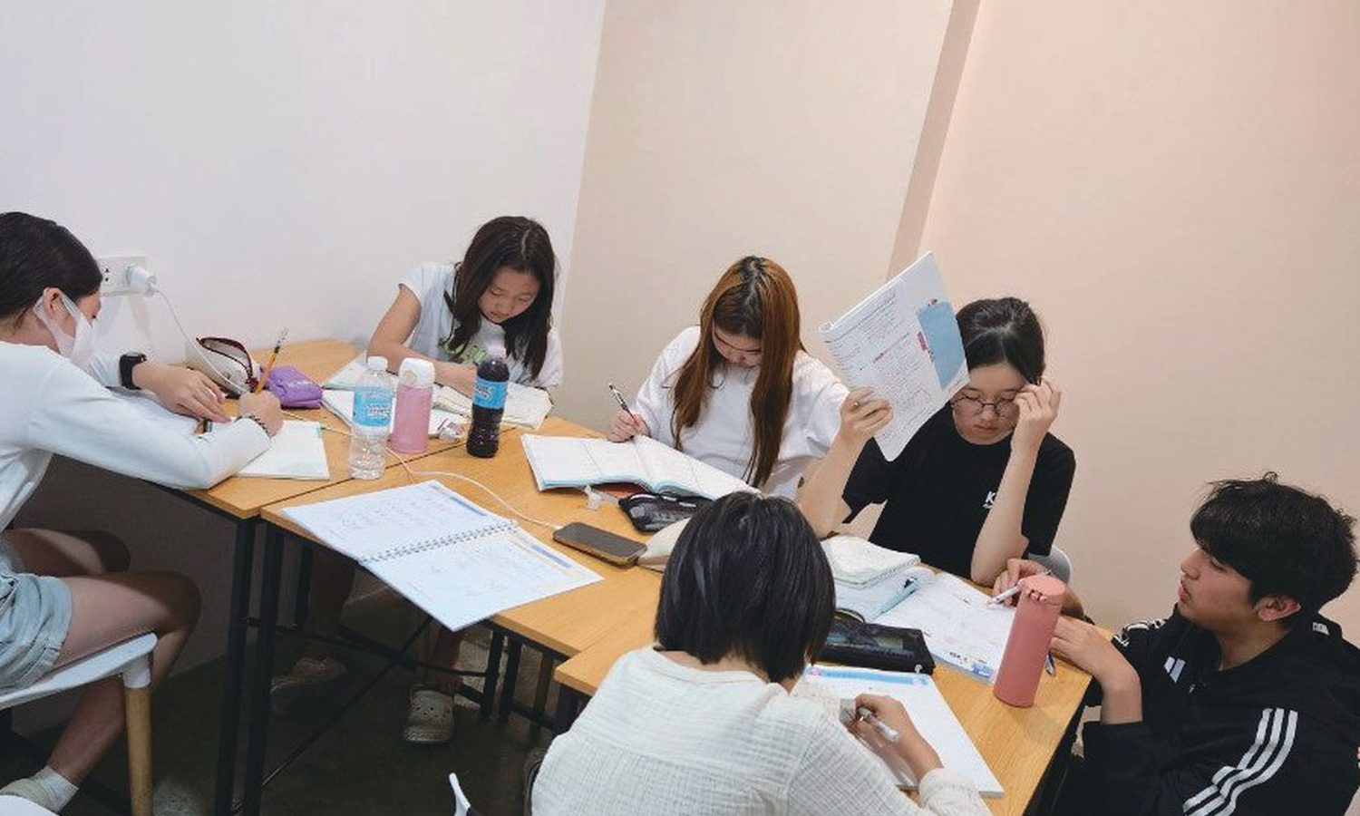 PIAのグループ授業。留学生5人が丸テーブルを囲んでプリントに取り組んでいる