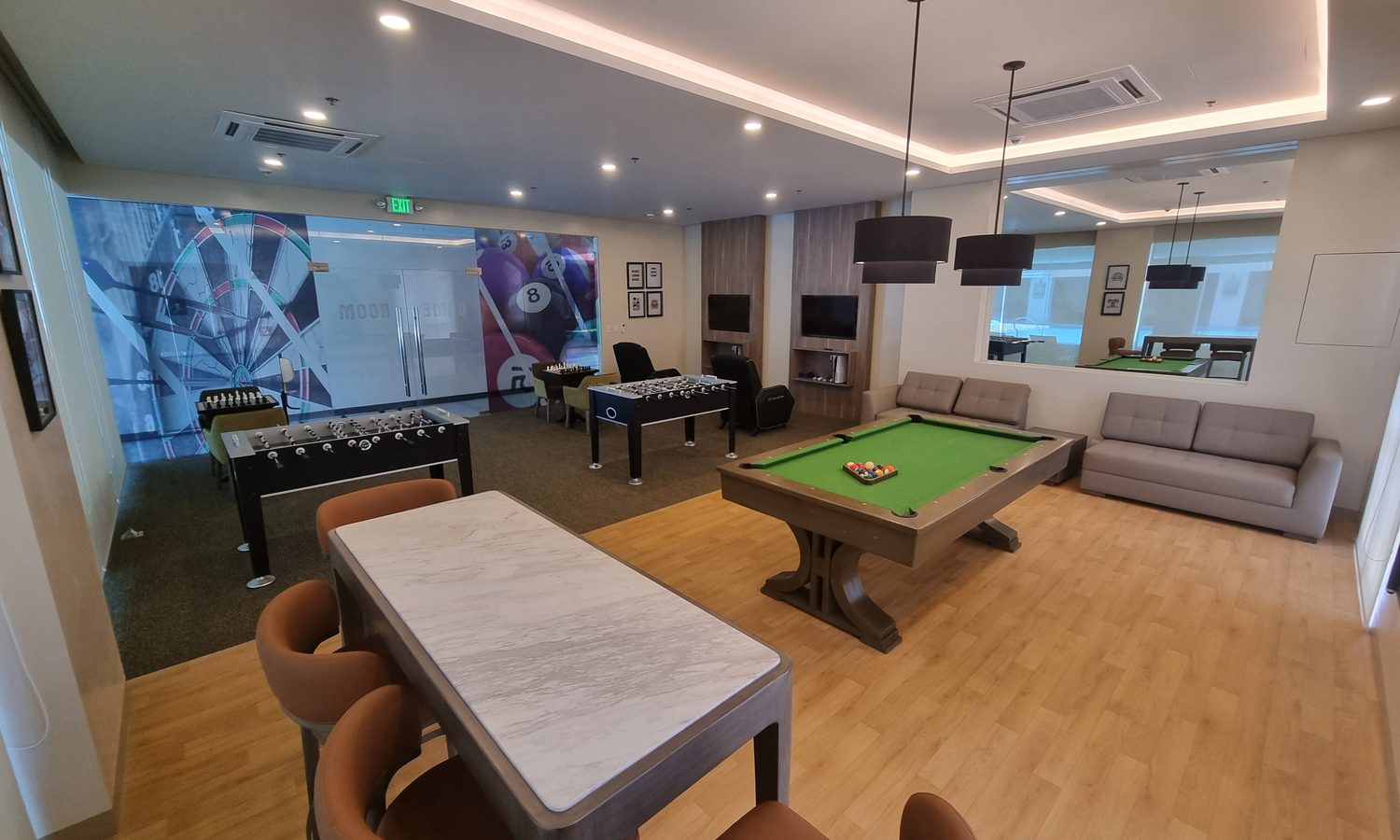 PIAの寮コンドミニアムのプレイルーム。ビリヤード台とテーブルサッカー、ソファがある
