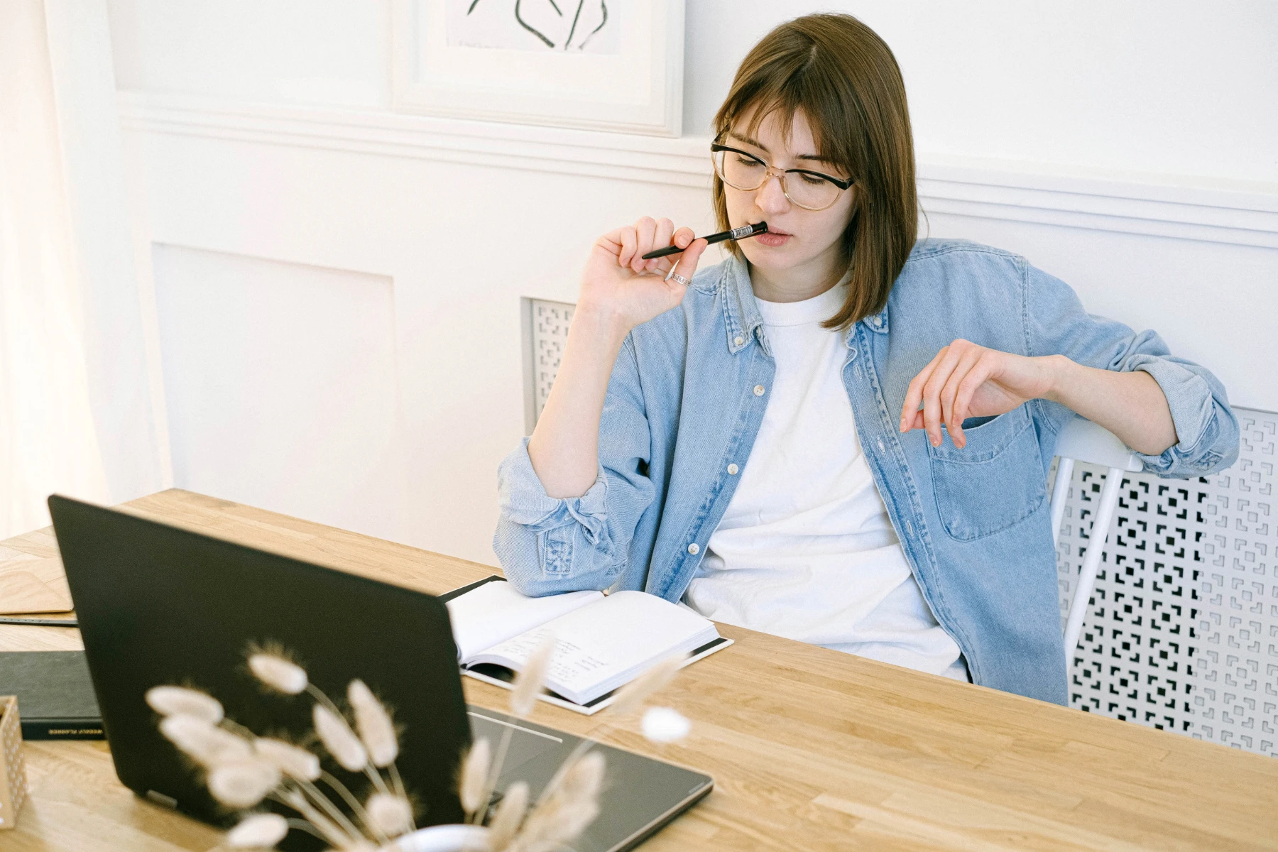 休職して留学を考えながら、ノートとパソコンで調べものをする社会人の女性