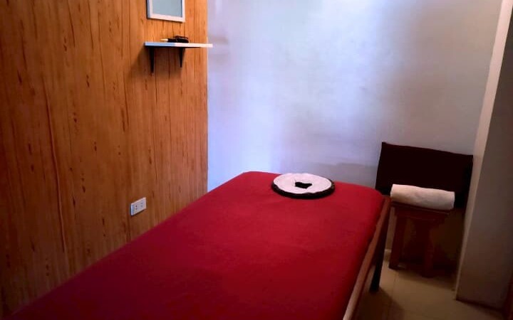 E-roomが運営するマッサージショップ内の様子。個室内に赤いマッサージ台が設置されている。
