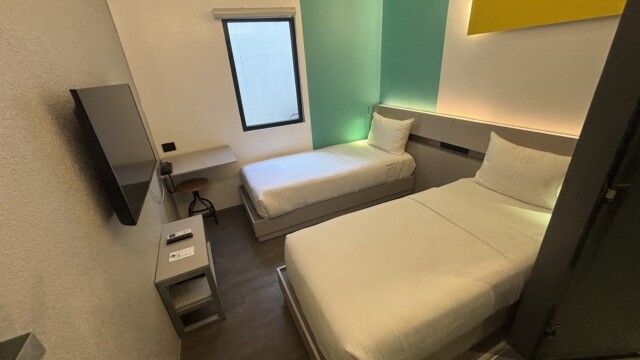 Yelloホテル寮の2人部屋。シングルベッド2台と窓ぎわのデスクがある