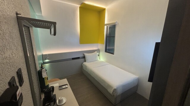 Yelloホテル寮の1人部屋。黄色と水色のアクセントがあるモダンな客室