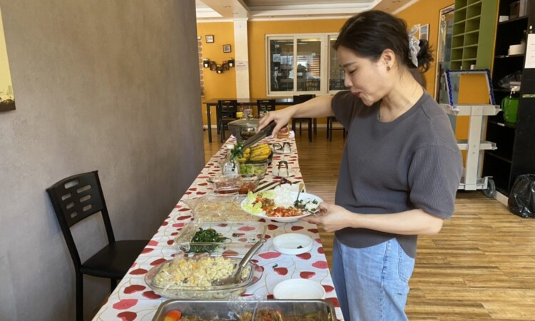 CIPのビュッフェ形式の食事。料理を取り分ける留学生