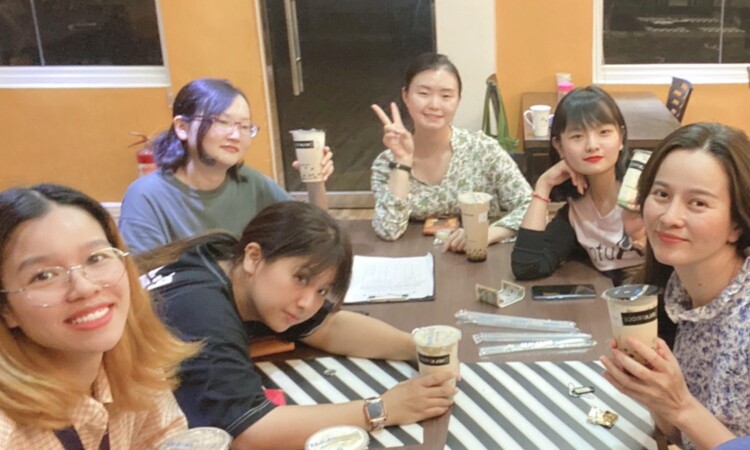 CIPのダイニングの本棚コーナーで飲み物を楽しむ留学生