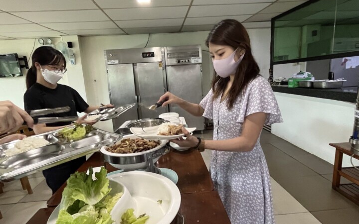 English Fella 2の学食のビュッフェ。留学生が料理を取り分けている