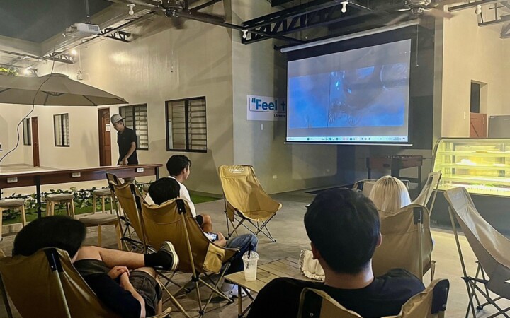 I.BREEZE のムービーナイト。スクリーンの前にキャンプチェアを並べて映画を見る留学生