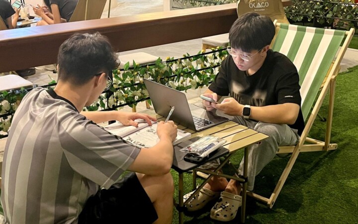 I.BREEZE プライム校のBreeze Cafeでキャンプチェアに座って勉強する学生