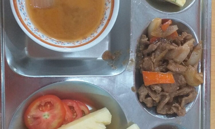 肉料理と果物が並んだトレイの食事