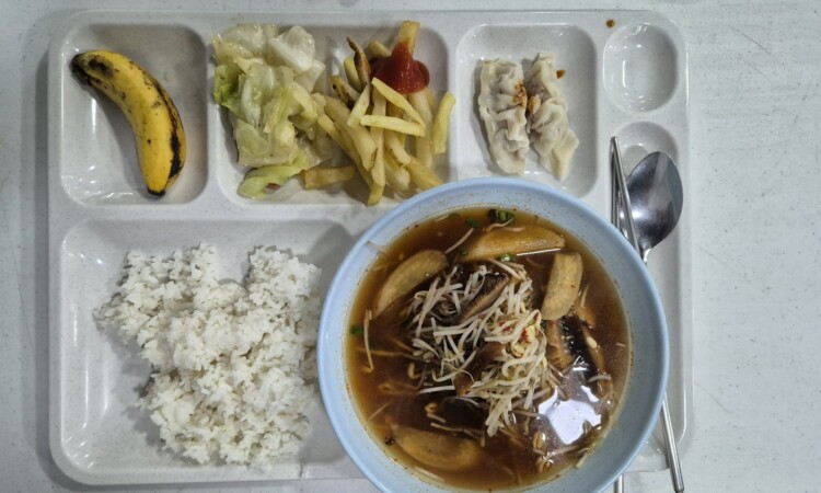 PIAの昼食。ご飯と魚の煮付け、野菜、バナナのトレー