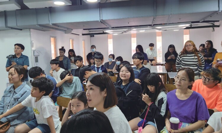 PIAの教室に集まった多国籍の留学生。親子留学の家族や大学生が並んで座っている