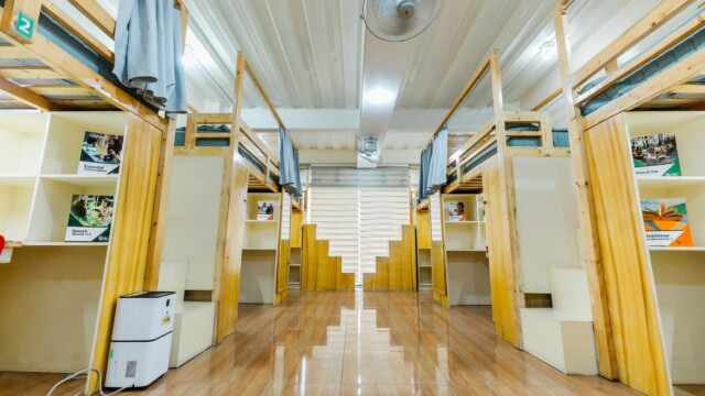 カーテン付きベッドと半個室デスクが並ぶPINESメイン校の6人部屋